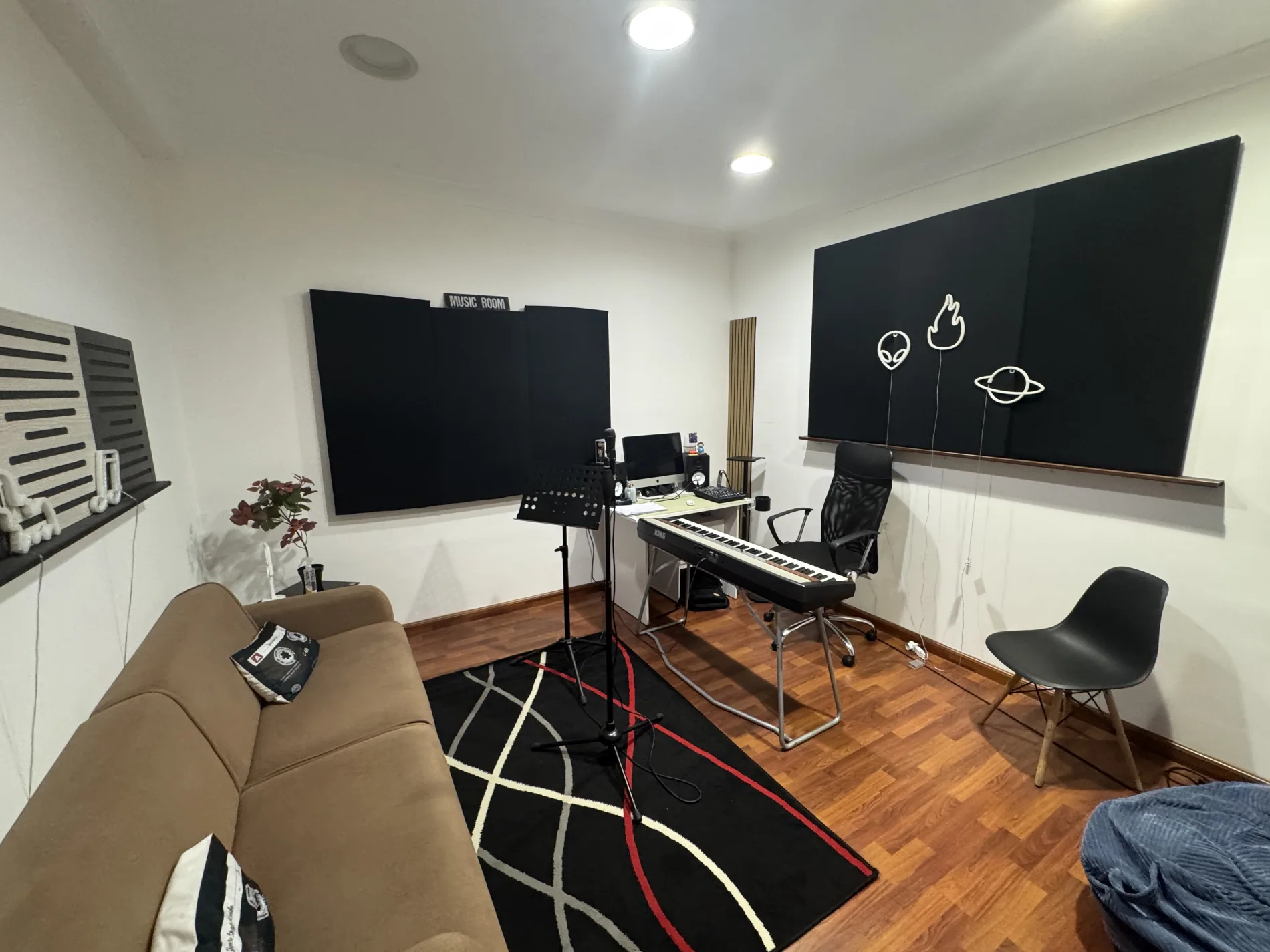 Music room RC Voce Produzione con pianoforte, microfono e pannelli acustici